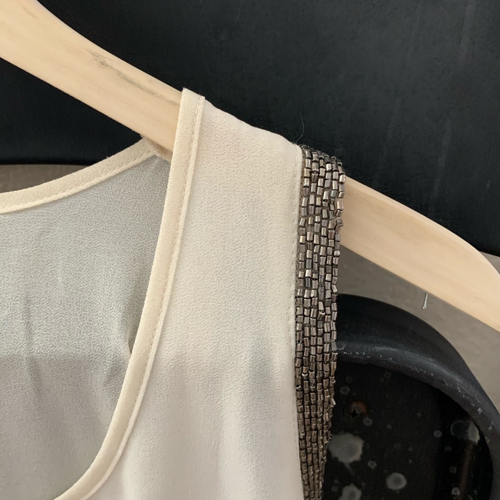 Cream colored blouse with metallic accent sleeve